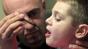 cannabisolie of cbdolie wordt in de mond van een kind gedruppeld